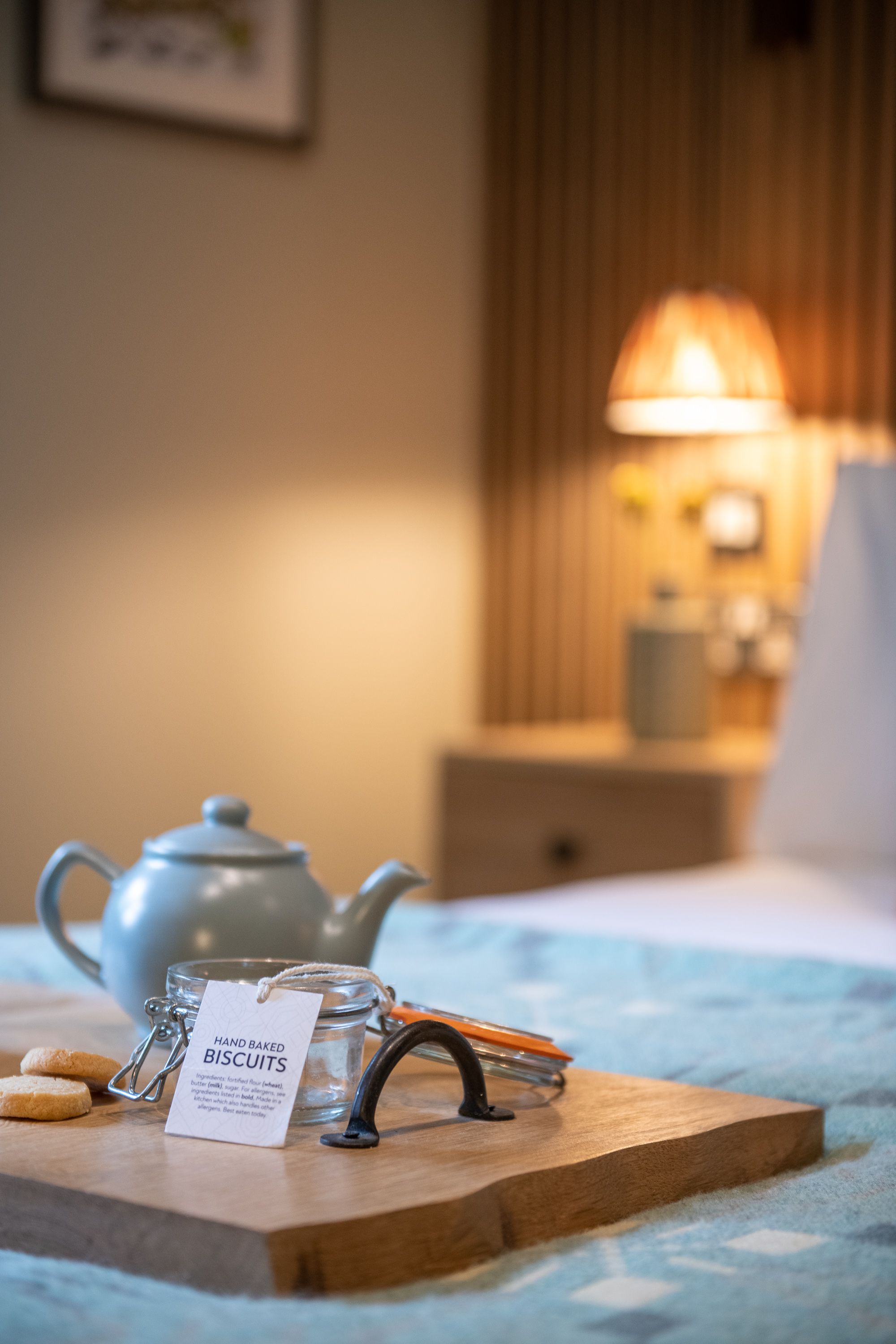 Teapot and handmade biscuits on a tray on the bed