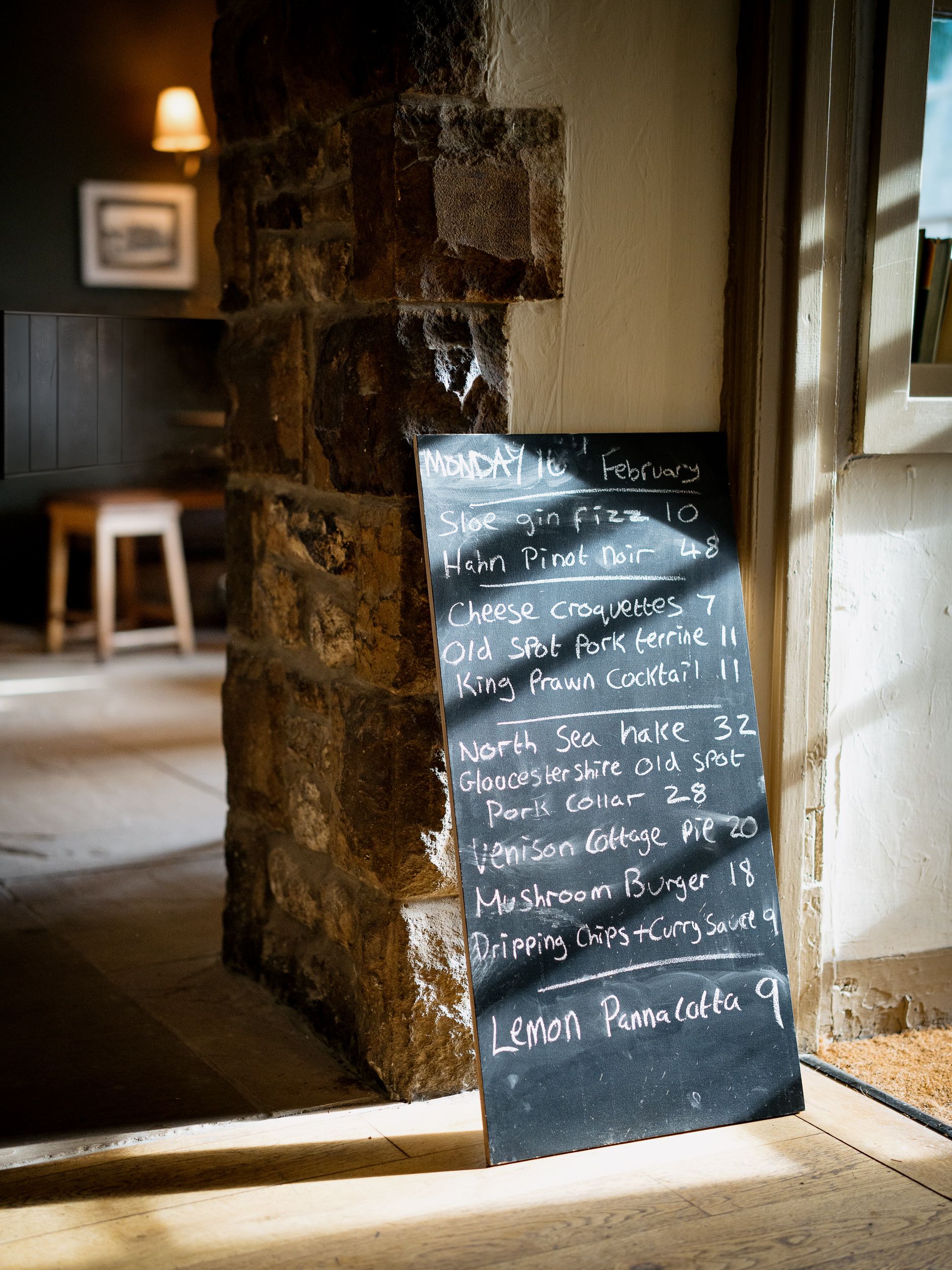 specials board by the entrance with the sun shining in